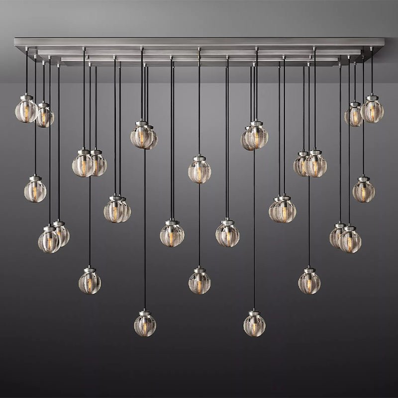 Linear chandelier with brushed nickel frame and multiple hanging clear glass globe pendants against a gray background.